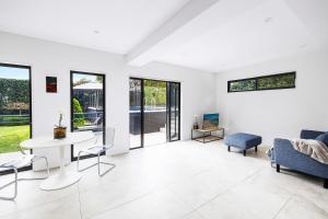 シドニーにあるKINGS10V - Luxe at Kingsのソファとテーブルと椅子のあるリビングルーム