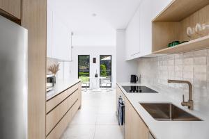 シドニーにあるKINGS10V - Luxe at Kingsの白いキャビネットとシンクのあるキッチン