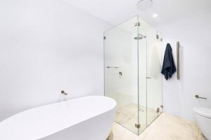 シドニーにあるKINGS10V - Luxe at Kingsのシャワーとトイレ付きの白いバスルーム