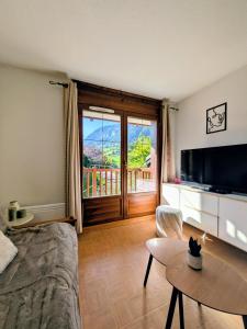 TV a/nebo společenská místnost v ubytování Appartement ski aux pieds & piscine - Flumet