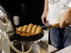 a person is cooking food in a grill at KOKO HOTEL Tokyo Nishikasai in Tokyo +57 photos