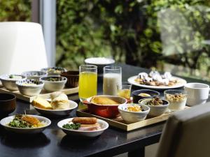 a table with plates of food and glasses of orange juice at KOKO HOTEL Tokyo Nishikasai in Tokyo