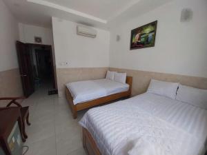 a hotel room with two beds and a tv at Khách Sạn Thiên Phúc in Ho Chi Minh City