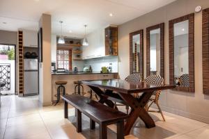 a kitchen with a wooden dining table and chairs at Avemore Mareba Court No 9 in Stellenbosch