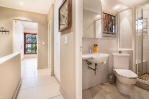 a white bathroom with a toilet and a sink at Avemore Mareba Court No 9 in Stellenbosch +24 photos