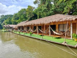 une rangée de cabanes sur l'eau à côté d'une rivière dans l'établissement Tayan Resort Kanchanaburi, à Ban Kao