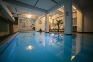 a swimming pool in a house with blue water at Hotel Orion in Ghent