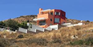 a house on the side of a hill with stairs at The Grand Beach House in Karistos