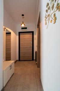 pasillo con puerta en una habitación con suelo de madera en Apartamente Miramare by Alz, en Mamaia Nord – Năvodari
