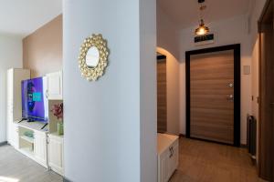 a hallway with a door with a mirror and a television at Apartamente Miramare by Alz in Mamaia Sat/Năvodari