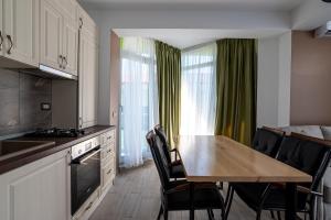 a kitchen and dining room with a table and chairs at Apartamente Miramare by Alz in Mamaia Sat/Năvodari