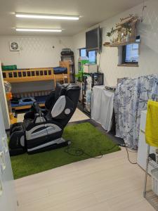 Barrier Free Guesthouse Support Included في أوساكا: غرفة بها كرسي موضوع على سجادة خضراء