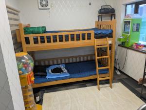 two bunk beds in a room with a desk at Barrier Free Guesthouse Support Included in Osaka