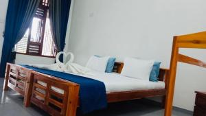 a bedroom with a bed with blue and white pillows at Coastal Heaven in Pottuvil