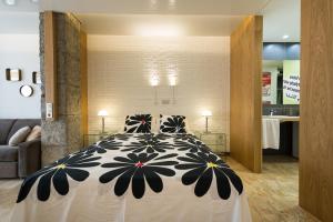 a bedroom with a bed with a black and white comforter at Suites Garden Loft Andy Warhol in Las Palmas de Gran Canaria