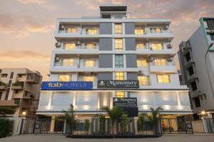 a tall white building with a sign in front of it at FabHotel Manomay Homes - Nr Manish Nagar in Nagpur