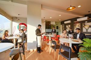 a group of people sitting at tables in a restaurant at FabHotel Manomay Homes - Nr Manish Nagar in Nagpur