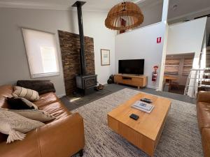 a living room with a couch and a wood stove at Three Bears 3 - Thredbo in Thredbo