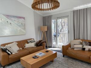 a living room with two couches and a coffee table at Three Bears 3 - Thredbo in Thredbo