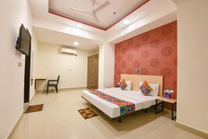 a bedroom with a bed and a tv in a room at FabHotel Blue Stone in New Delhi