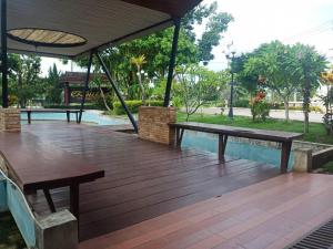 two benches sitting on a wooden deck in a park at CK Hills Hotel in Mae Sot