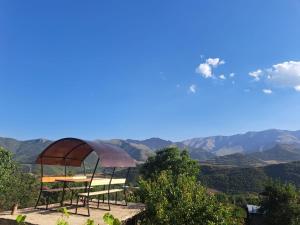 a table and chairs with a view of mountains at Elmira B&B in Tatʼev