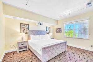 una camera da letto con un letto grande e una finestra di Ocean View Duplex Penthouse Retreat amenities: tennis court heated Pool Vista Key One a Islamorada Altre 32 foto