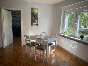 a dining room with a table and four chairs at Ferienwohnung Nelly in Wermelskirchen