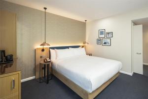 a bedroom with a large white bed and a table at Hilton Garden Inn Bristol City Centre in Bristol