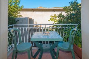 a table and two chairs on a balcony at La Casa in Gallura piano terra in Calangianus