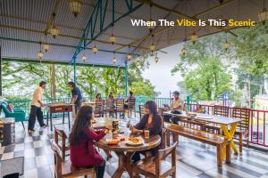 a group of people sitting at tables in a restaurant at goSTOPS Mussoorie Clock Tower in Mussoorie