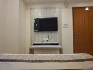 バラナシにあるThe Banaras Paradiseのベッド1台、薄型テレビが備わる客室です。