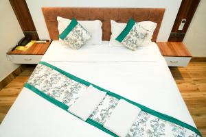a bedroom with a bed with white sheets and pillows at Naina Staycation Udaipur in Udaipur