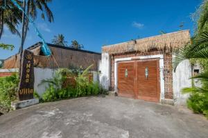 a garage with a wooden door in front of a building at Maha Villa 1 Kertha Mandala in Amed +59 photos