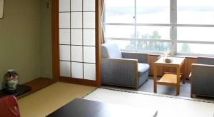 a living room with a couch and a window at Hotel New Katsura in Sado