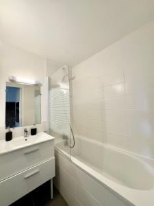 a white bathroom with a sink and a bath tub at Le Saint Georges avec terrasse, Hyper centre ville in Rennes +30 photos