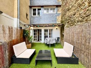 a backyard with two chairs and a table and a fence at Le Saint Georges avec terrasse, Hyper centre ville in Rennes