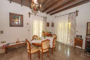 a dining room with a table and chairs and a chandelier at Green Yard Family Holiday Home Sidari Corfu in Antipernoí