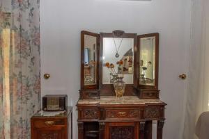 a wooden table with two mirrors and a vase on it at Green Yard Family Holiday Home Sidari Corfu in Antipernoí +25 photos