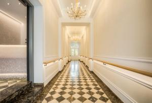 a hallway with a checkered floor and a chandelier at Vienna Grand Apartments City in Vienna