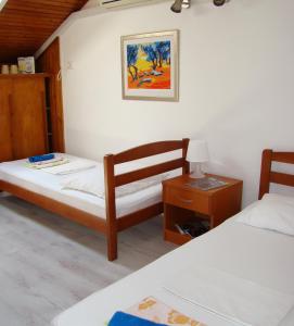 1 dormitorio con 2 camas, mesa y una foto en Hostel Saint Ursula Rooms, en Dubrovnik