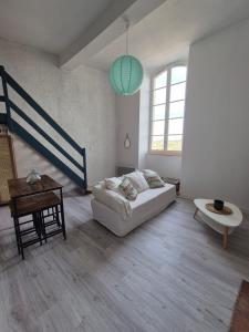 a white living room with a couch and a table at T2 moderne hypercentre - vue imprenable sur la ville in Auch