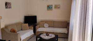 a living room with a couch and a tv at Angies House in Neos Panteleimonas