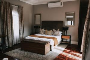 a bedroom with a large bed and a mirror at The Rasmus in Pretoria
