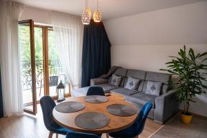 a living room with a table and a couch at Apartamenty Stasikówka in Poronin