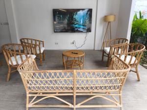 a room with chairs and a table and a tv at Omah Gili Hotel in Gili Air