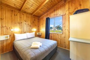 a bedroom with a bed in a wooden room at Heatherbrae Holiday Village in Heatherbrae +44 photos