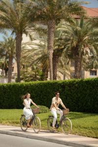 Un homme et une femme qui roulent à vélo dans une rue dans l'établissement Sofitel Dubai The Palm Resort & Spa, à Dubaï