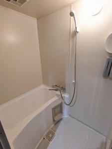 a bathroom with a shower and a bath tub at Loghouse HOKA -バレルサウナ付貸切別荘 大型犬ペット可 in Kama +12 photos