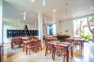 a restaurant with wooden tables and chairs in a room at Gudi Boutique Resort in Mae Rim